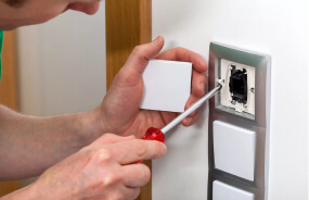 Электрик устанавливает выключатель в квартире