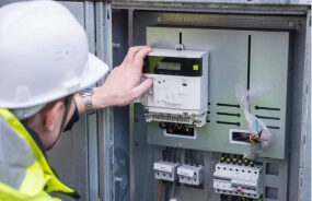 Мастер производит монтаж электрического счетчика