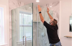 Мастер 4-house устанавливает душевую кабину в ванной