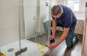 Сантехник демонтирует душевую кабину